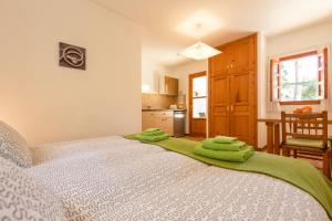 1 dormitorio con 1 cama con toallas verdes en Residence Can Confort Formentera, en Sant Francesc Xavier