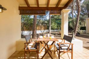 a wooden table and chairs on a patio at Residence Can Confort Formentera in Sant Francesc Xavier