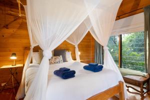 una camera da letto con un letto a baldacchino con asciugamani blu sopra di Worendo Cottages a Darlington