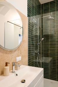 een badkamer met wastafel en douche met spiegel bij Helles Design-Loft im Zentrum mit Schlossbergblick in Graz +14 foto's