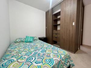 a bedroom with a bed and a wooden cabinet at Apartamento con vista a las Montañas in Ibagué +8 photos