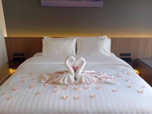 two hearts shaped towels on a bed with roses at The Richer Ratchaburi in Ratchaburi
