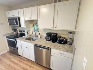 ヒルトン・ヘッド・アイランドにあるUpdated 2 bedroom Beach Bungalow - Walk to the beachの白いキャビネットとカウンタートップを備えたキッチン