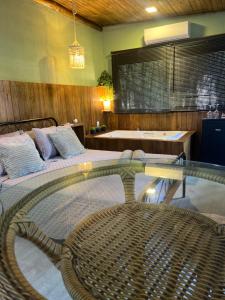a room with a bed and a glass table at Mandala Camping Pousada in Florianópolis