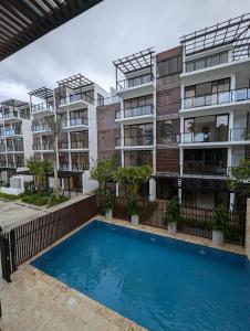 an apartment building with a swimming pool in front of it at Marbella in San Felipe de Puerto Plata