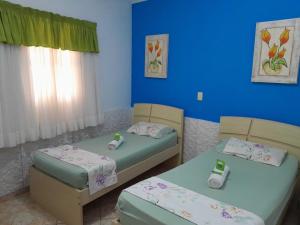 two beds in a room with blue walls at Cantinho do Paraíso in Águas de Lindóia +32 photos