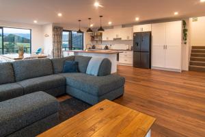 a living room with a couch and a kitchen at Stunning Views, Contemporary, Escape - KK24113 in Kaikoura