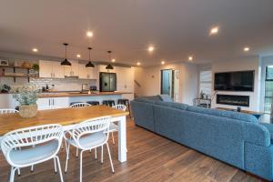 a living room with a blue couch and a table and chairs at Stunning Views, Contemporary, Escape - KK24113 in Kaikoura
