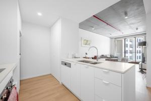 a white kitchen with white cabinets and a sink at Modern 2 Bedroom Apartment in Phillip with Parking in Phillip +5 photos