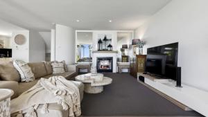 a living room with a couch and a fireplace at Solara - Sleeps 8, Beach, Walk To Resorts, Views in Coffs Harbour +16 photos