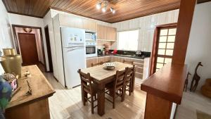 a kitchen with a wooden table and a white refrigerator at Casa do Sobrado in Bagé