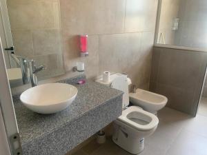 a bathroom with a sink and a toilet and a mirror at Dormis Sinsacate in Sinsacate +9 photos