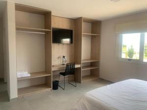 a bedroom with a bed and a desk and a television at Dormis Sinsacate in Sinsacate