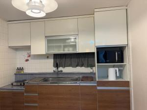 una cucina con mobili bianchi e un lavandino di 7pp aloha stay OlympicPark KSPO JYP LotteWorld a Seul