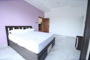 a bedroom with a large bed with white sheets at Blackpool Complex - Lavender in Trincomalee