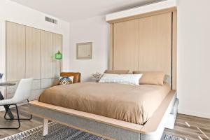 a bedroom with a large bed and a desk at Modern Hollywood Studio, Pool Parking Gym in Los Angeles