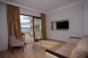 a living room with a couch and a television at Pasa Garden Beach in Marmaris