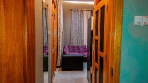a hallway with a chair and a couch in a room at RJ's Apartments Korogwe in Korogwe +4 photos