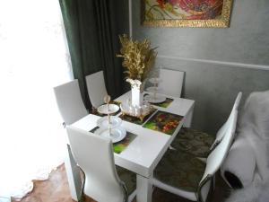 アドレルにあるApartment Kurortnyi Gorodokの白いダイニングテーブル(白い椅子付)、白いテーブル、チェアトップ