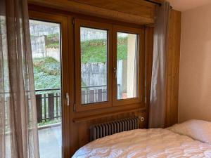 a bedroom with a bed and a window with a view at Apartment Veysonnaz near Ski Lift 4 Vallées in Veysonnaz