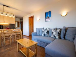 a living room with a blue couch and a table at Spacious apartment with view in Nendaz