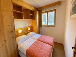 a small bedroom with a bed and a window at Spacious apartment with view in Nendaz