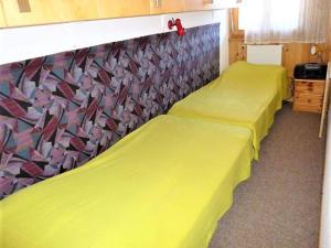 two beds in a room with yellow sheets at Apartment in Veysonnaz near Ski Gondola in Veysonnaz