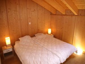 a bedroom with a white bed in a wooden cabin at Chalet in Veysonnaz with mountain view in Veysonnaz