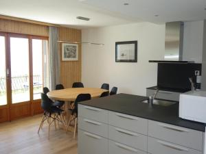 a kitchen and dining room with a table and a television at Apartment in Veysonnaz with Private Balcony in Veysonnaz