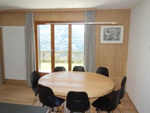 a table and chairs in a room with a large window at Apartment in Veysonnaz with Private Balcony in Veysonnaz +12 photos