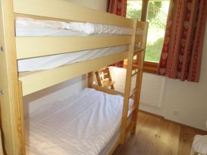 two bunk beds in a room with a window at Apartment in Veysonnaz with Private Balcony in Veysonnaz