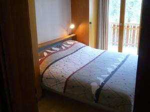 ein Schlafzimmer mit einem Bett in einem Zimmer mit einem Fenster in der Unterkunft Apartment in Veysonnaz with ski room in Veysonnaz