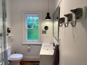 a bathroom with a sink and a toilet and a window at 'The Gardenia' Trentham in Trentham