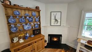 a living room with a fireplace and blue and white ceramics at 'The Gardenia' Trentham in Trentham