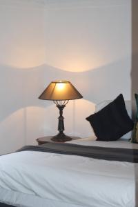 a lamp sitting on a table next to a bed at 'The Gardenia' Trentham in Trentham