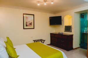 a bedroom with a bed and a flat screen tv at Hotel Puebla de Antaño in Puebla