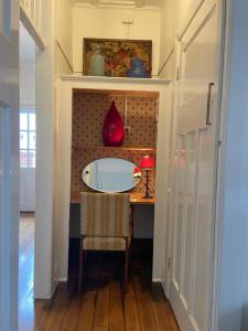 a dining room table with a red vase on a wall at 'The Gardenia' Trentham in Trentham