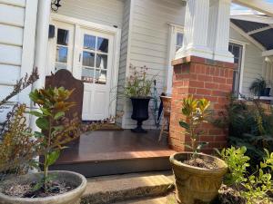 a porch of a house with potted plants on it at 'The Gardenia' Trentham in Trentham