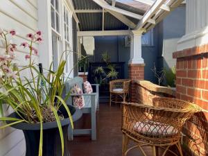 a patio with wicker chairs and plants on a house at 'The Gardenia' Trentham in Trentham