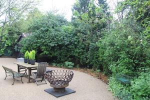 a patio with a table and chairs and trees at 'The Gardenia' Trentham in Trentham