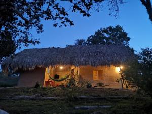a small hut with a thatched roof at night at Eco Hostel Oro de Gaque in San Gil