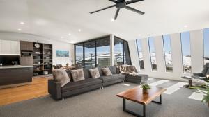 a living room with a couch and a ceiling fan at Burramungee - 5 Bedroom Chalet in Mount Hotham