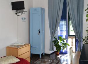 sypialnia z niebieską szafką obok okna w obiekcie B&B Blue Home w Genui