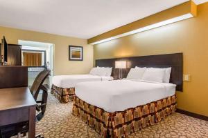 a hotel room with two beds and a desk at Ramada by Wyndham Santee I-95 in Santee +19 photos