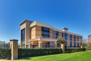 un edificio con una valla delante de un patio en Heritage Inn Suites Houston Sugar Land, Trademark by Wyndham, en Sugar Land