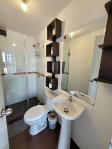 ein weißes Badezimmer mit Toilette und Waschbecken in der Unterkunft Modern and comfortable apartment nearby Aairport in Lima