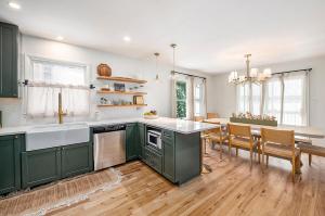 a kitchen with green cabinets and a dining room at New Beach front 5bd in Sister Lakes with Hot tub in Dowagiac
