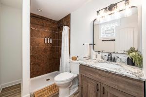 a bathroom with a toilet and a sink and a shower at New Beach front 5bd in Sister Lakes with Hot tub in Dowagiac +14 photos