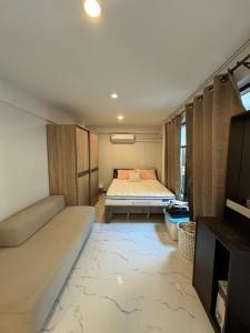 Ban Na SongにあるFirst Villa Life Hostel 民宿のベッドとソファのある小さな部屋