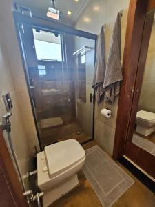 a bathroom with a toilet and a shower at Suite Memorália Mar 1 in Arraial do Cabo